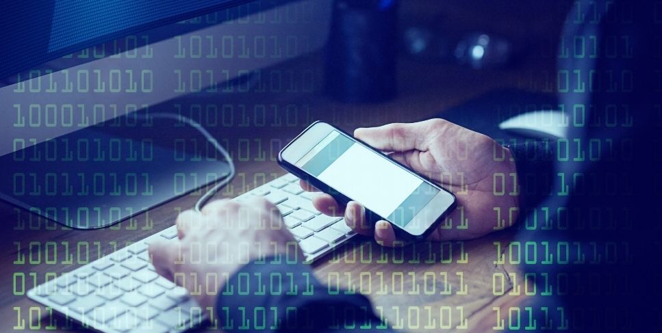 Person using a computer and checking their phone