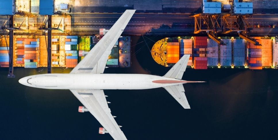 Plane flying over cargo ships