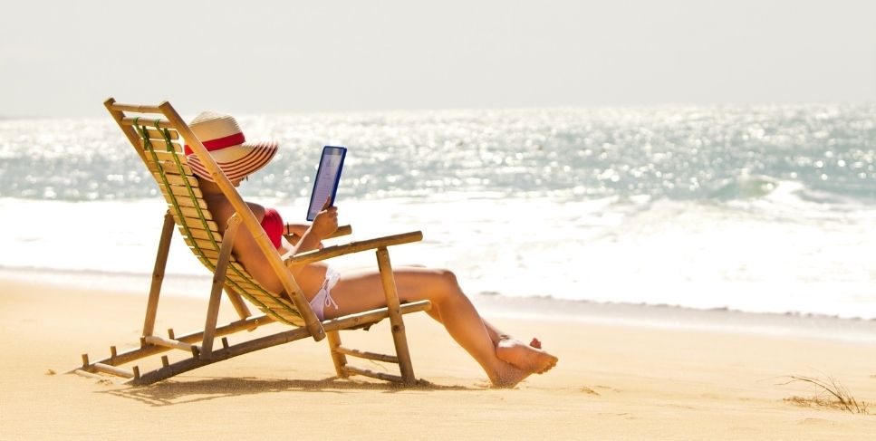 Lady on beach reading a tablet