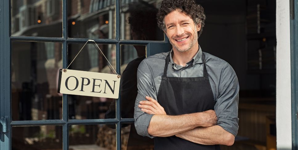 Person standing in front of a shop with an open sign