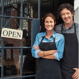 Business Owners in front of an open sign